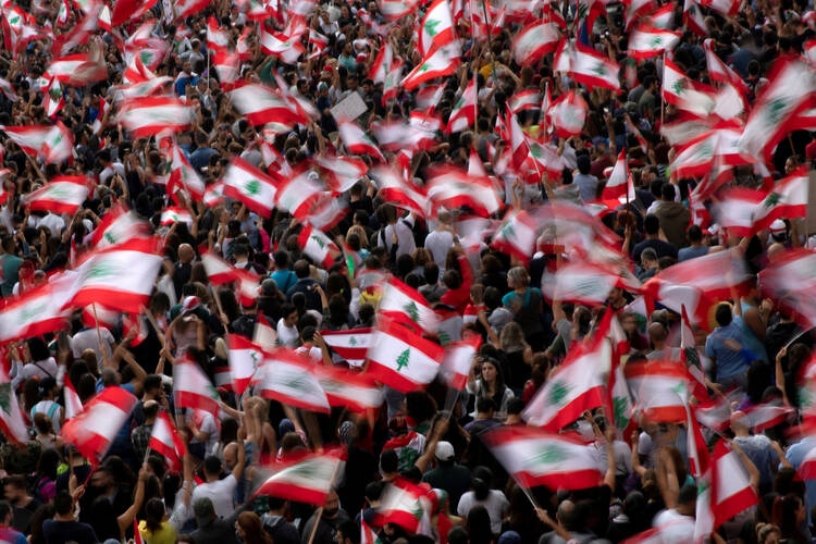 Demonstrators wave Lebanese flags during an anti-government protest on a highway in Jal el-Dib Oct. 23, 2019. The Oct. 29 resignation of Lebanese Prime Minister Saad Hariri followed 13 days of massive country-wide demonstrations. (CNS photo/Alkis Konstantinidis, Reuters)