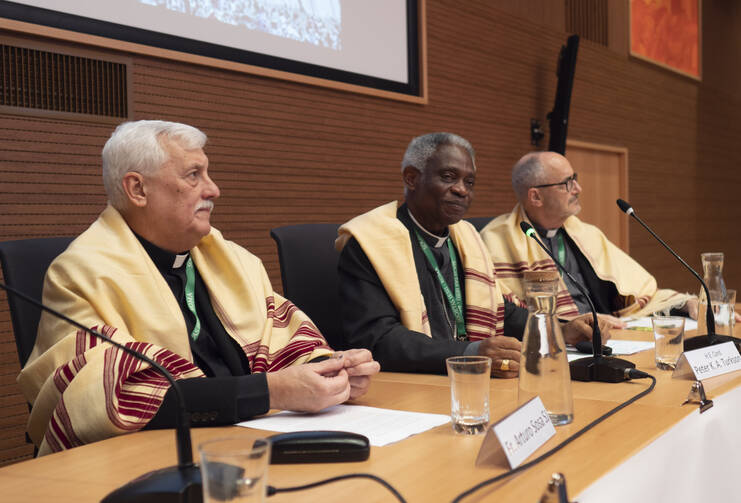 Father Arturo Sosa, superior general of the Jesuits, Cardinal Peter Turkson, prefect of the Dicastery for Promoting Integral Human Development, and Cardinal Michael Czerny, undersecretary of the Migrants and Refugee Section of the Vatican Dicastery for Promoting Integral Human Development, attend a meeting in Rome Nov. 4, 2019. The meeting marked 50 years of the Jesuits' Social Justice and Ecology Secretariat. (CNS photo/courtesy Jesuits) 