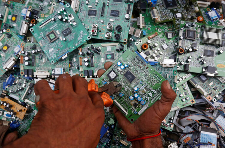 A man in Karachi, Pakistan, retrieves circuit boards from discarded computer monitors Aug. 16, 2017. An economic system lacking any ethics leads to a "throwaway" culture of consumption and waste, Pope Francis said in a speech addressed to members of the Council for Inclusive Capitalism during an audience at the Vatican Nov. 11. (CNS photo/Akhtar Soomro, Reuters) 