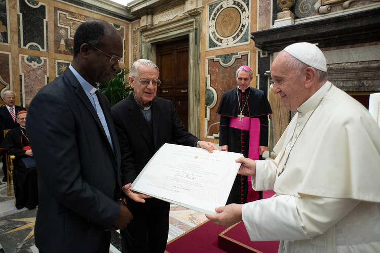 Pope Francis presents the Ratzinger prize to Jesuit Father Paul Bere during a ceremony at the Vatican Nov. 9, 2019. Father Bere and philosopher Charles Taylor were chosen as prize winners by the Joseph Ratzinger-Benedict XVI Foundation. (CNS photo/Vatican Media)