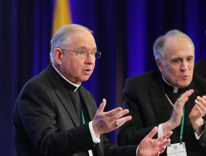 Cardinal Daniel N. DiNardo of Galveston-Houston, president of the U.S. Conference of Catholic Bishops, right, applauds as Archbishop Jose H. Gomez of Los Angeles acknowledges the applause after being named the new president during the fall general assembly of the USCCB in Baltimore Nov. 12, 2019. (CNS photo/Bob Roller) 