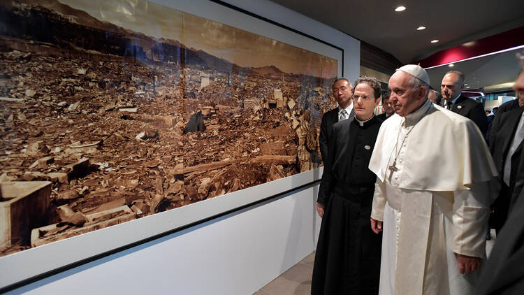 Pope Francis walks by a photo showing the destruction of an atomic bomb during a visit to the Jesuit-run Sophia University in Tokyo on Nov. 26, 2019. (CNS photo/Vatican Media via Reuters)