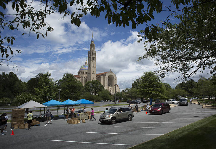 Catholic Charities staff and volunteers in the Archdiocese of Washington distribute 500 grocery boxes and 500 family meals in the parking lot of the Basilica of the National Shrine of the Immaculate Conception July 10, 2020, during the coronavirus pandemic. (CNS photo/Tyler Orsburn)