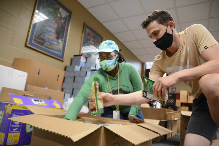 Andrea Dowlen, left, an Americorps worker with Catholic Charities of Tennessee, and Matthew Grimes, a Catholic Charities volunteer, fill emergency food boxes July 7, 2020, for people who have been affected by the COVID-19 pandemic and the March 3 tornadoes. The boxes contain enough food to feed two people for five to seven meals. (CNS photo/Andy Telli, Tennessee Register)