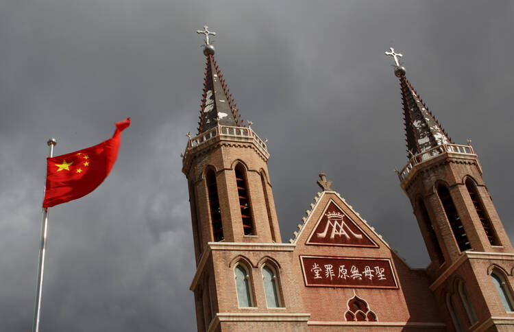 07.21.2020 The Chinese national flag flies in front of a Catholic church in Huangtugang, China, in this 2018 photo. As the Vatican-China agreement on the naming of bishops approaches two years, Beijing is still lagging behind in giving concessions compared with those made ahead of the deal by the Vatican. (CNS photo/Thomas Peter, Reuters)
