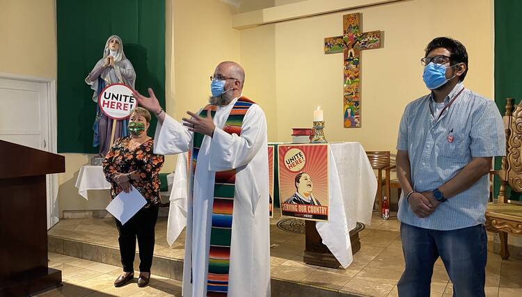 Brendon Busse, S.J., center, celebrates a Mass at Dolores Mission Church in Los Angeles on June 20 for hospitality workers to view online. (Courtesy Unite Here Local 11)