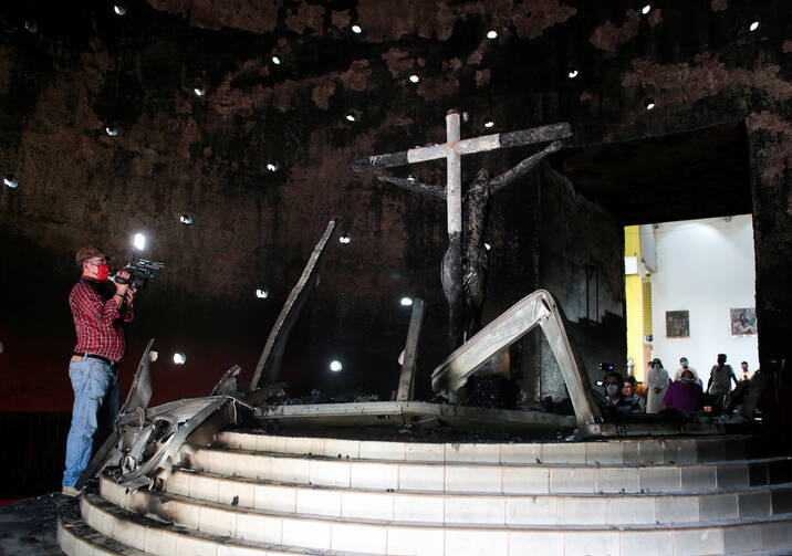 A videographer is seen in the Blood of Christ Chapel at the Metropolitan Cathedral in Managua, Nicaragua, July 31, 2020, after was it destroyed in an arson attack. (CNS photo/Oswaldo Rivas, Reuters)