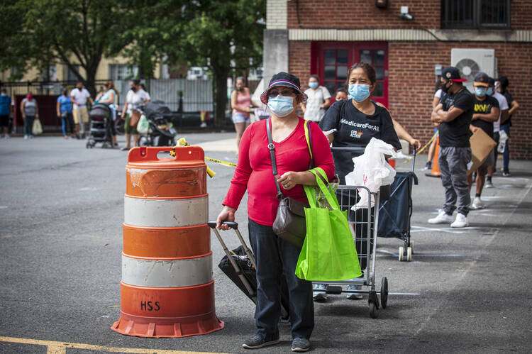 A woman waits in line at Catholic Charities' Spanish Catholic Center parking lot in Washington July 15, 2020, to pick up free food supplies. Catholic Charities USA agencies have provided nearly $400 million in assistance during the first four months of the coronavirus pandemic. (CNS photo/Chaz Muth)