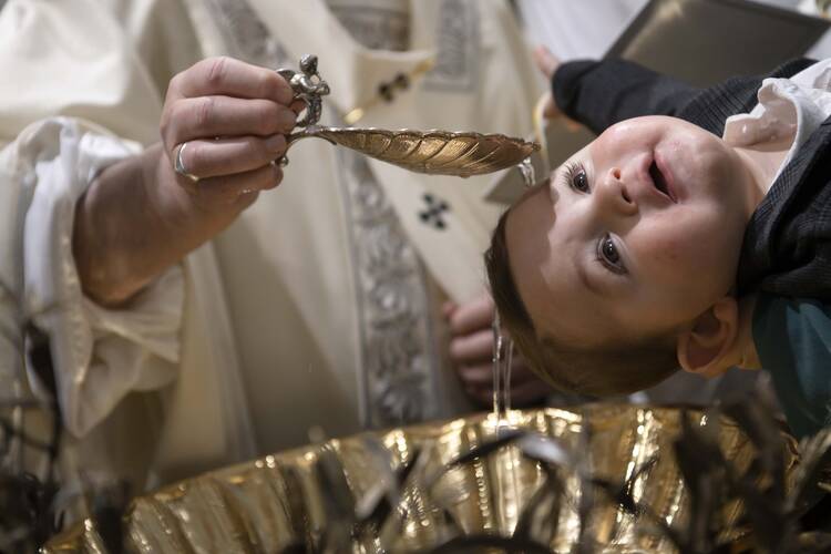 Pope Francis baptizes a baby as he celebrates Mass on the feast of the Baptism of the Lord in the Sistine Chapel at the Vatican Jan. 12, 2020. (CNS photo/Vatican Media)