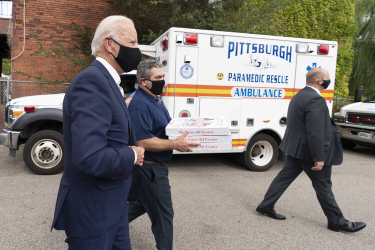 Democratic presidential candidate former Vice President Joe Biden arrives with pizza as he visits Pittsburgh Local Fire Fighters No. 1 in Pittsburgh, Pa., Monday, Aug. 31, 2020. (AP Photo/Carolyn Kaster)