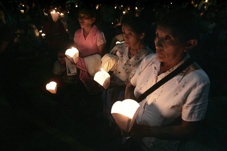 A file photo shows Salvadorans gathering during a candlelight service in San Salvador to commemorate the 1989 killing of six Jesuits and two women during El Salvador's civil war. (CNS photo/Luis Galdamez, Reuters)