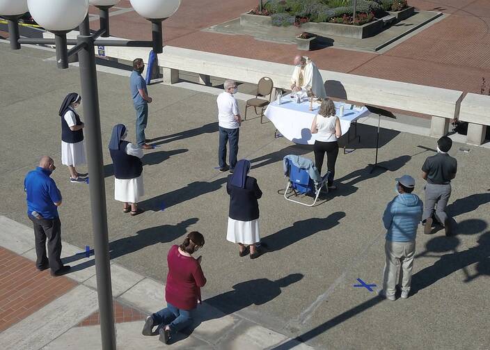 Jesuit Father John Piderit, San Francisco's archdiocesan vicar for administration, celebrates Mass simultaneously with three other priests on the feast of the Assumption near the steps of the city's Cathedral of St. Mary of the Assumption Aug. 15, 2020. (CNS photo/Dennis Callahan, Archdiocese of San Francisco)