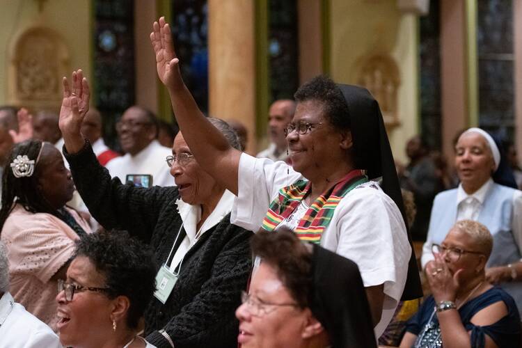 Sister Beulah Martin, a member of the Sisters of the Blessed Sacrament, center right, of Powhatan, Va., waves in Baltimore's historic St. Francis Xavier Church July 22, 2019, at a Mass honoring jubilarians during a joint conference of black priests, women religious, deacons and seminarians. (CNS photo/Kevin J. Parks, Catholic Review)