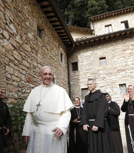 Pope Francis greets religious as he leaves the hermitage and cell of St. Francis in Assisi, Italy, in this Oct. 4, 2013, file photo. The pope plans to visit Assisi on Oct. 3 to celebrate a private Mass and sign his new encyclical on human fraternity. (CNS photo/Paul Haring)