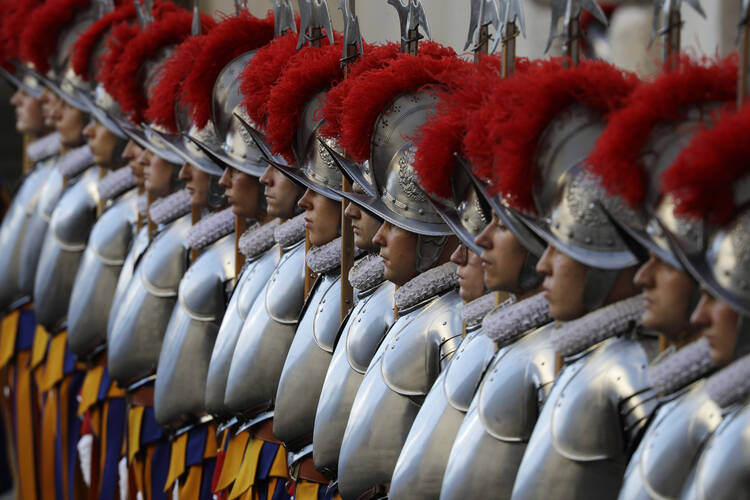 In this Oct. 4, 2020 file photo, Vatican Swiss Guards stand attention at the St. Damaso courtyard on the occasion of their swearing-in ceremony, at the Vatican, Sunday, Oct. 4, 2020. On Monday, Oct. 12, 2020, the Vatican said in a statement that four Swiss Guards have tested positive for the coronavirus, as the surge in infections in surrounding Italy enters the Vatican walls. (AP Photo/Gregorio Borgia, file)