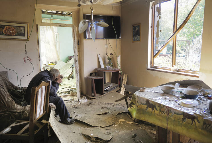 Yury Melkonyan, 64, sits in his house, damaged by shelling from Azerbaijan's artillery during a military conflict in Shosh village outside Stepanakert, the separatist region of Nagorno-Karabakh, Saturday, Oct. 17, 2020. (AP Photo)