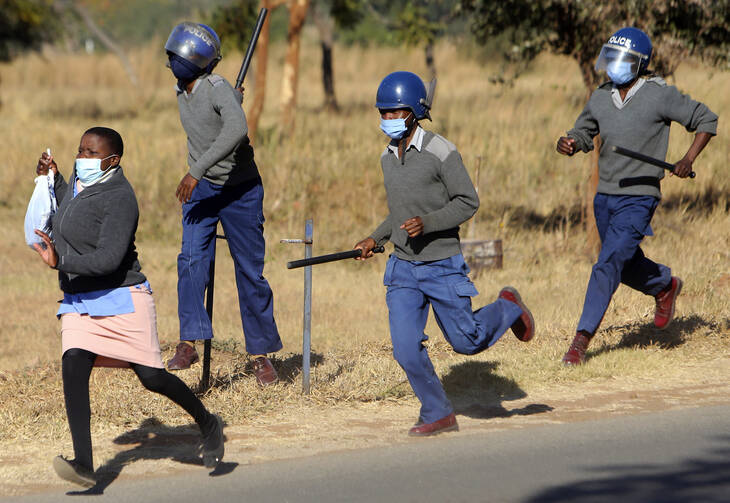 Zimbabwe riot police break up a protest for better pay and personal protective equipment by nurses in Harare in July. (AP photo/Tsvangirayi Mukwazhi)
