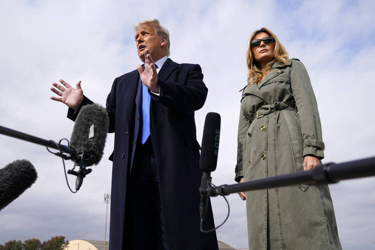 President Donald Trump talks to reporters, as first lady Melania Trump listens, before boarding Air Force One for a day of campaign rallies in Michigan, Wisconsin and Nebraska on Tuesday, Oct. 27. (AP Photo/Evan Vucci)