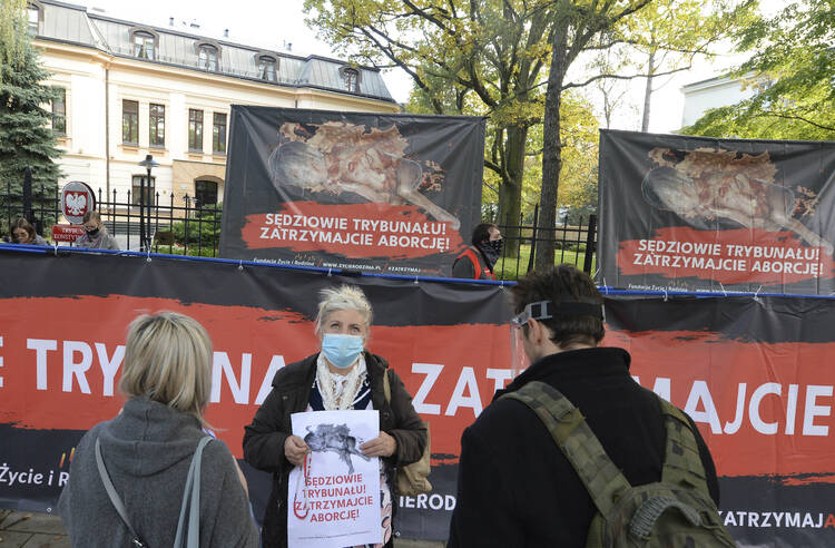 Anti-abortion activists display images of fetuses at a protest in front of Poland's constitutional court, in Warsaw, on Oct. 22, following the ruling that a Polish law allowing the abortion of fetuses with congenital defects is unconstitutional. (AP Photo/Czarek Sokolowski)