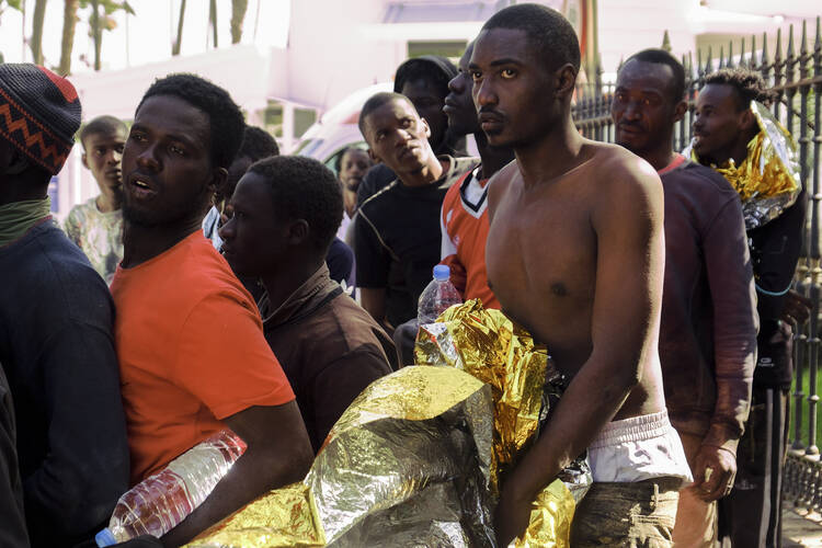 Newly arrived migrants are transferred by Spanish police to a temporary location after arriving at the coast of Gran Canaria island, Spain, on Nov. 1. Crossing the Atlantic Ocean sailing on a wooden boat, a group of 44 migrants had arrived at Maspalomas beach. (AP Photo/Javier Bauluz)