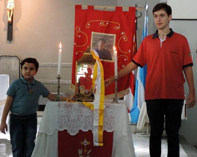 Matheus Vianna and Gabriel Terron pose before a relic of Carlo Acutis in 2015. Photo courtesy of St. Sebastian's church in Campo Grande, Mato Grosso do Sul, Brazil.