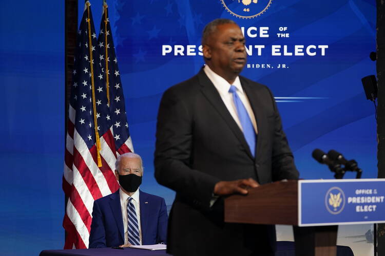 President-elect Joe Biden looks on as retired Army Gen. Lloyd Austin, Biden's choice to be secretary of defense, speaks at The Queen theater in Wilmington, Del., on Dec. 9. (AP Photo/Susan Walsh)