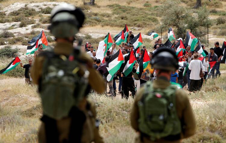 Israeli soldiers in Bethlehem stand guard on May 10, 2018, as Palestinians demonstrate ahead of Israeli Independence Day. (CNS photo/Mussa Qawasma, Reuters)