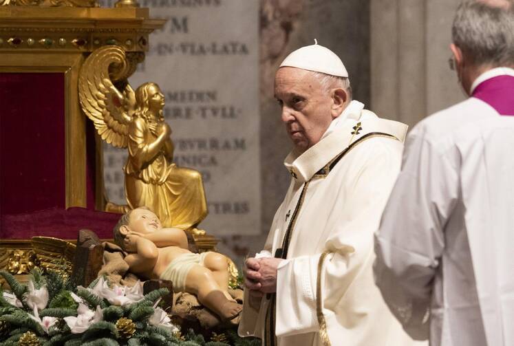 Pope Francis walks near a figurine of the baby Jesus as he celebrates Mass in St. Peter's Basilica at the Vatican Dec. 24, 2020. (CNS photo/Cristian Gennari, pool)