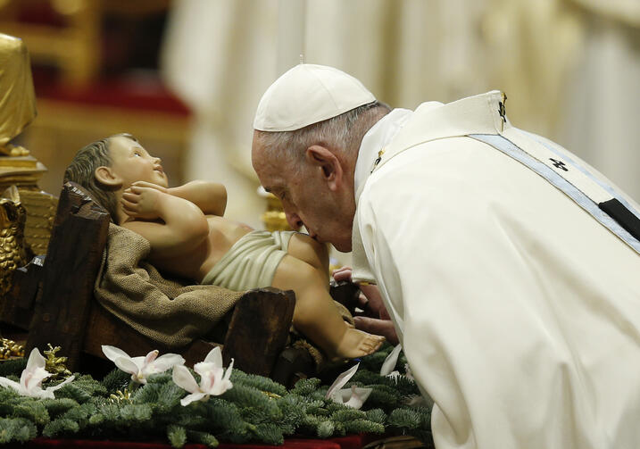 Pope Francis kisses a figurine of the baby Jesus at the start of Mass on the feast of Mary, Mother of God, in St. Peter's Basilica at the Vatican Jan. 1, 2020. (CNS photo/Paul Haring) 
