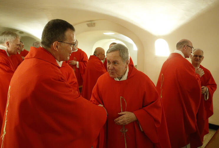 Archbishop Robert J. Carlson of Saint Louis, center, offers the sign of peace to Bishop William M. Joensen Des Moines, Iowa, as U.S. bishops from Iowa, Kansas, Missouri and Nebraska concelebrate Mass in the crypt of St. Peter's Basilica at the Vatican Jan. 16, 2020. The bishops were making their "ad limina" visits to the Vatican to report on the status of their dioceses to the pope and Vatican officials. (CNS photo/Paul Haring) 