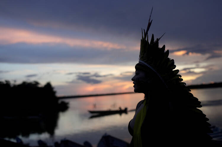 A leader of the Celia Xakriaba peoples walks along the banks of the Xingu River, a tributary of the Amazon, in Brazil’s Xingu Indigenous Park on Jan. 15, 2020. (CNS photo/Ricardo Moraes, Reuters)