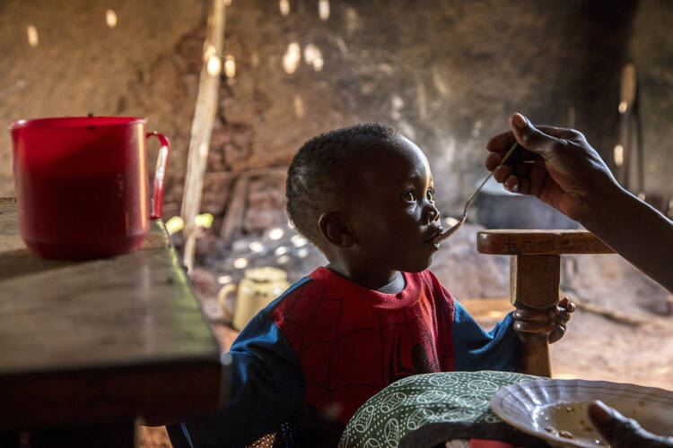 A grandmother who has been part of a Catholic Relief Services' program for family nutrition shares her lunch with her youngest of seven grandchildren in the kitchen of the family home in Konjiko, Kenya, in May 2019. Lenten alms donated through the CRS Rice Bowl program support the agency's work in roughly 45 different countries. (CNS photo/Georgina Goodwin for Catholic Relief Services) 