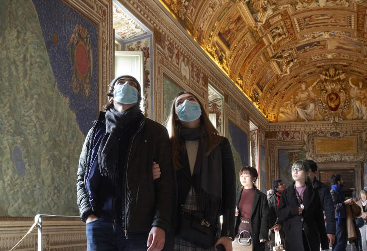 People wearing masks for protection from the coronavirus tour the Vatican Museums at the Vatican Feb. 29. (CNS photo/Paul Haring)