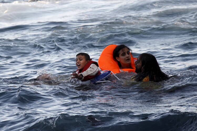  A boy cries out for help as a half-sunken catamaran carrying around 150 refugees, most of them Syrians, arrives at the Greek island of Lesbos, Oct. 30, 2015. Turkey and Greece are trading blame following the deaths of Syrian refugees trying to flee to Europe. (CNS photo/Giorgos Moutafis, Reuters) 