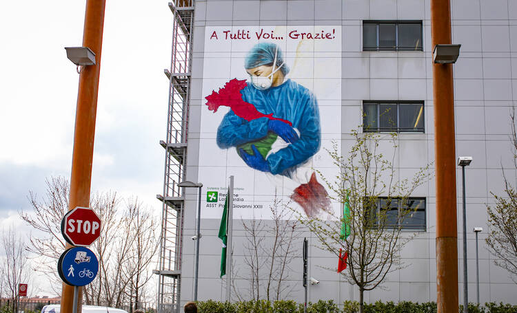 A mural depicts a nurse embracing the shape of Italy posted on the hospital of Pope John XXIII in solidarity with the health workers in Bergamo on March 13, 2020. (CNS photo/Sergio Agazzi, IPA/ABACAPRESS.COM via Reuters) 