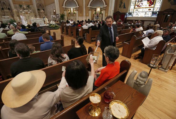 An usher at Notre Dame de Chicago Church in Chicago collects funds June 2, 2019. The Archdiocese of Chicago launched a site to collect donations to help parishes and those in need during the coronavirus shutdown, which has forced the cancellation of all public Masses for foreseeable future. (CNS photo/Karen Callaway, Chicago Catholic)
