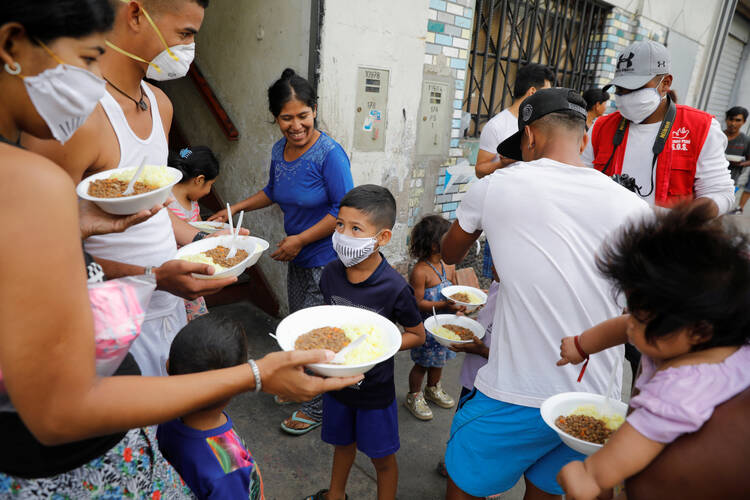 Haitians and Venezuelans receive food aid from church members in Lima, Peru, March 30, 2020. (CNS photo/Sebastian Castaneda, Reuters)