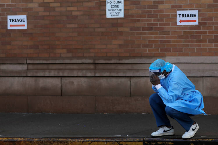 A health care worker outside the emergency center at Maimonides Medical Center, in New York City, on April 13. (CNS photo/Andrew Kelly, Reuters)