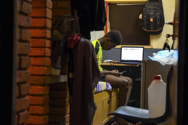 A student chats on his phone in his room at an engineering school in Ouagadougou, Burkina Faso, April 1, 2020, during the COVID-19 pandemic. (CNS photo/Anne Mimault, Reuters)