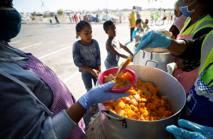 Children wait in line for food at a school near Cape Town, South Africa, May 4, 2020, during the COVID-19 pandemic. (CNS photo/Mike Hutchings, Reuters) 