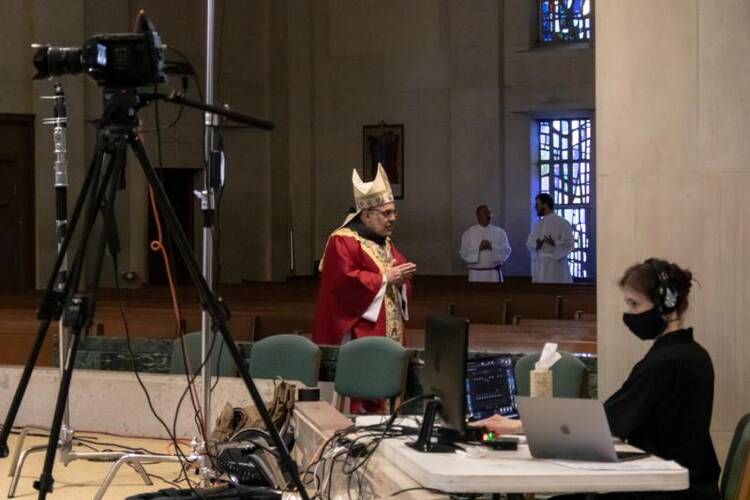 Bishop John E. Stowe of Lexington, Ky., is captured on camera for livestream as he celebrates Palm Sunday Mass in his diocese's nearly empty Cathedral of Christ the King April 5, 2020, amid the coronavirus pandemic. (CNS photo/Deacon Skip Olson, courtesy Diocese of Lexington)