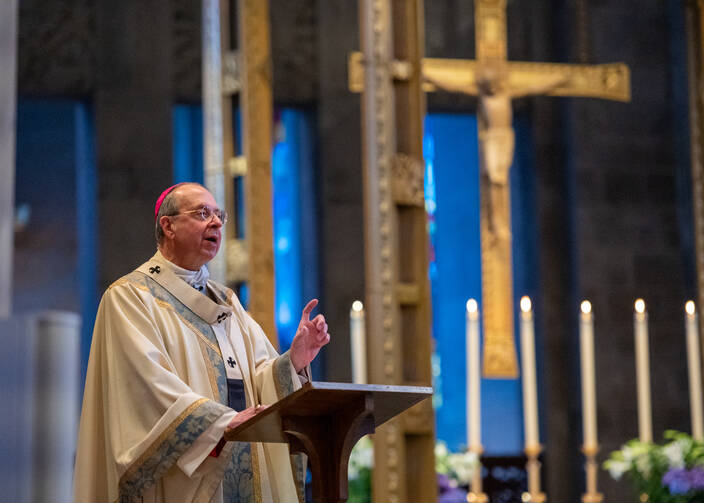 Archbishop William E. Lori of Baltimore delivers Easter Mass homily in the nearly empty Cathedral of Mary Our Queen. Archbishop Lori is among the U.S. church leaders who have released guidelines for reopening parishes. (CNS photo/Kevin Parks, Catholic Review)