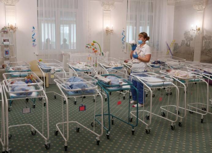 A nurse and newborns are seen in the Hotel Venice, which is owned by BioTexCom. a surrogacy agency in Kyiv, Ukraine, May 14, 2020. Dozens of babies born to surrogate mothers are stranded in Ukraine as the COVID-19 pandemic lockdown prevents their foreign parents from collecting them. The country's Catholic bishops have called for a halt to commercial surrogacy. (CNS photo/Gleb Garanich, Reuters)