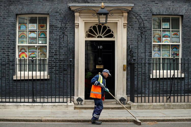 A street cleaner sweeps outside a residence in London May 4, 2020, during the COVID-19 pandemic. (CNS photo/John Sibley, Reuters)