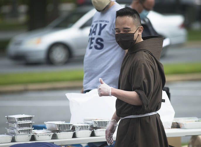 Capuchin Franciscan Brother Andrew Corriente hands out food to those in need in Washington, D.C., on May 19. Staff from the Archdiocese of Washington's Catholic Charities and volunteers distributed 800 boxes of food outside the Basilica of the National Shrine of the Immaculate Conception. (CNS photo/Tyler Orsburn)