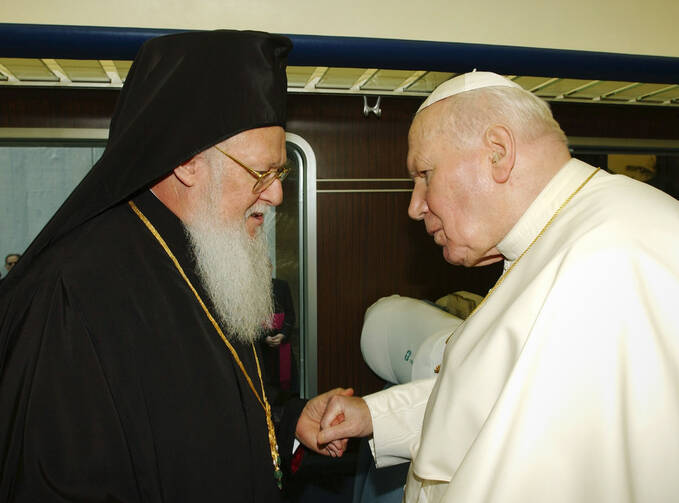 St. John Paul II greets Ecumenical Patriarch Bartholomew in 2002. Marking the 25th anniversary of St. John Paul II's encyclical on Christian unity, Pope Francis said he shares "the healthy impatience" of those who think more can and should be done, but he also insisted that Christians must be grateful for the progress made. (CNS photo/Reuters) 