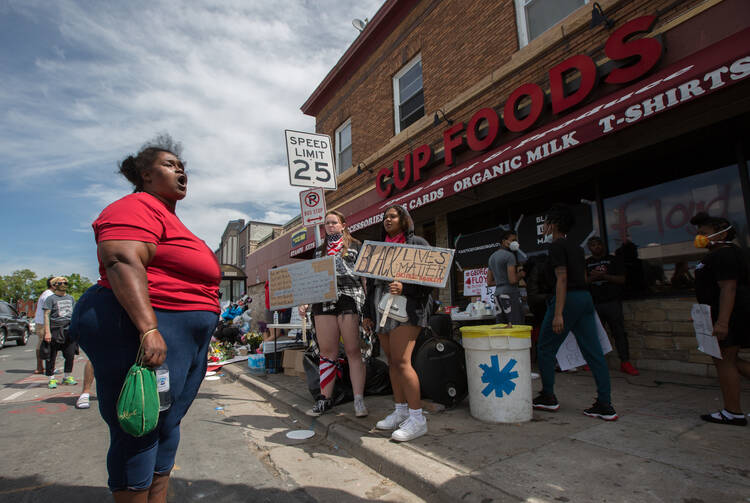 A woman in Minneapolis expresses her anger and frustration on May 28, at the site where George Floyd was pinned down on May 25 by a police officer; he was later pronounced dead at a local hospital. (CNS photo/Dave Hrbacek, The Catholic Spirit)