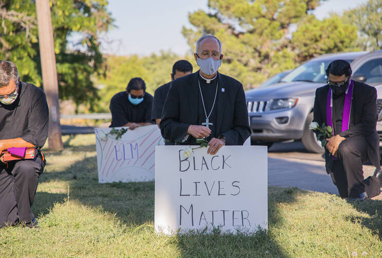  Bishop Mark J. Seitz of the Diocese of El Paso, Texas, kneels at El Paso's Memorial Park holding a Black Lives Matter sign June 1, 2020. Bishop Seitz and other clergy from the Diocese of El Paso, prayed and kneeled for eight minutes, the time George Floyd, an unarmed black man, was said to have spent under a police officer's knee before becoming unconscious and later dying May 25, 2020. (CNS photo/Fernie Ceniceros, courtesy Diocese of El Paso) 