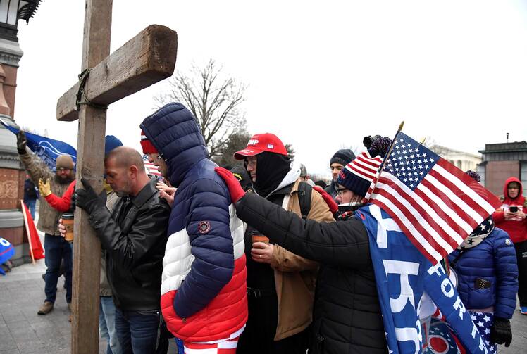  Supporters of President Donald Trump join in prayer outside the U.S. Capitol in Washington Jan. 6, 2021, where U.S. Congress will meet in joint session to certify the Electoral College vote for President-elect Joe Biden. (CNS photo/Mike Theiler, Reuters)