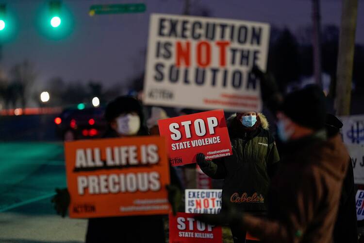 Demonstrators in in Terre Haute, Ind., gather to protest the execution of Lisa Montgomery on Jan. 12. She was put to death by lethal injection at the federal prison in Terre Haute soon after the U.S. Supreme Court lifted a hold on her execution at 1:31 a.m. (EST). She was the first woman to be put to death in federal prison since 1953. (CNS photo/Bryan Woolston, Reuters)